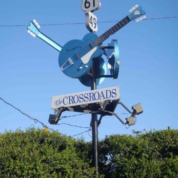 Crossroads with 3 blue guitar statues on a pole is a marker for Highways 61 and 49 in Mississippi
